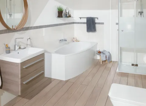Helles Badezimmer mit Holzboden und Badewanne von Mauerberger. 