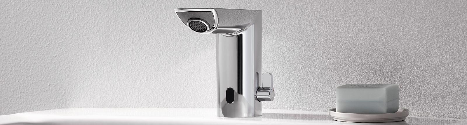 Silberne Elektronik-Armatur von GROHE und Seife